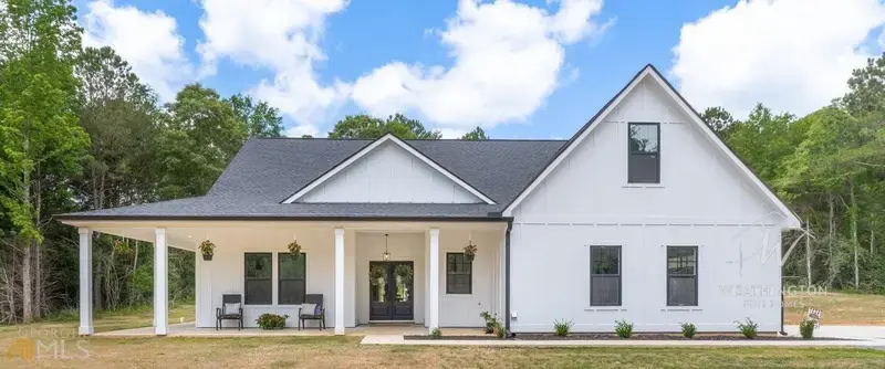 Custom farmhouse with covered porch and hanging baskets built by Weathington Fine Homes in Griffin Georgia